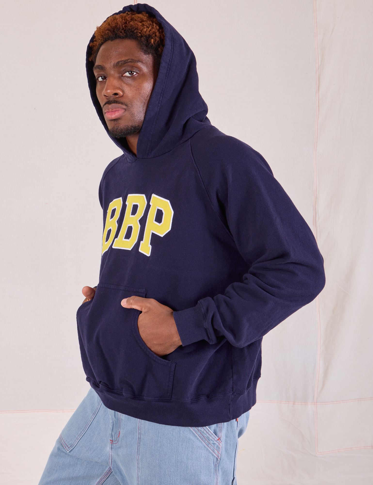 Collegiate Hoodie in Navy Blue side view on Issac