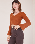 Angled view of Bell Sleeve Top in Burnt Terracotta and espresso brown Western Pants worn by Alex