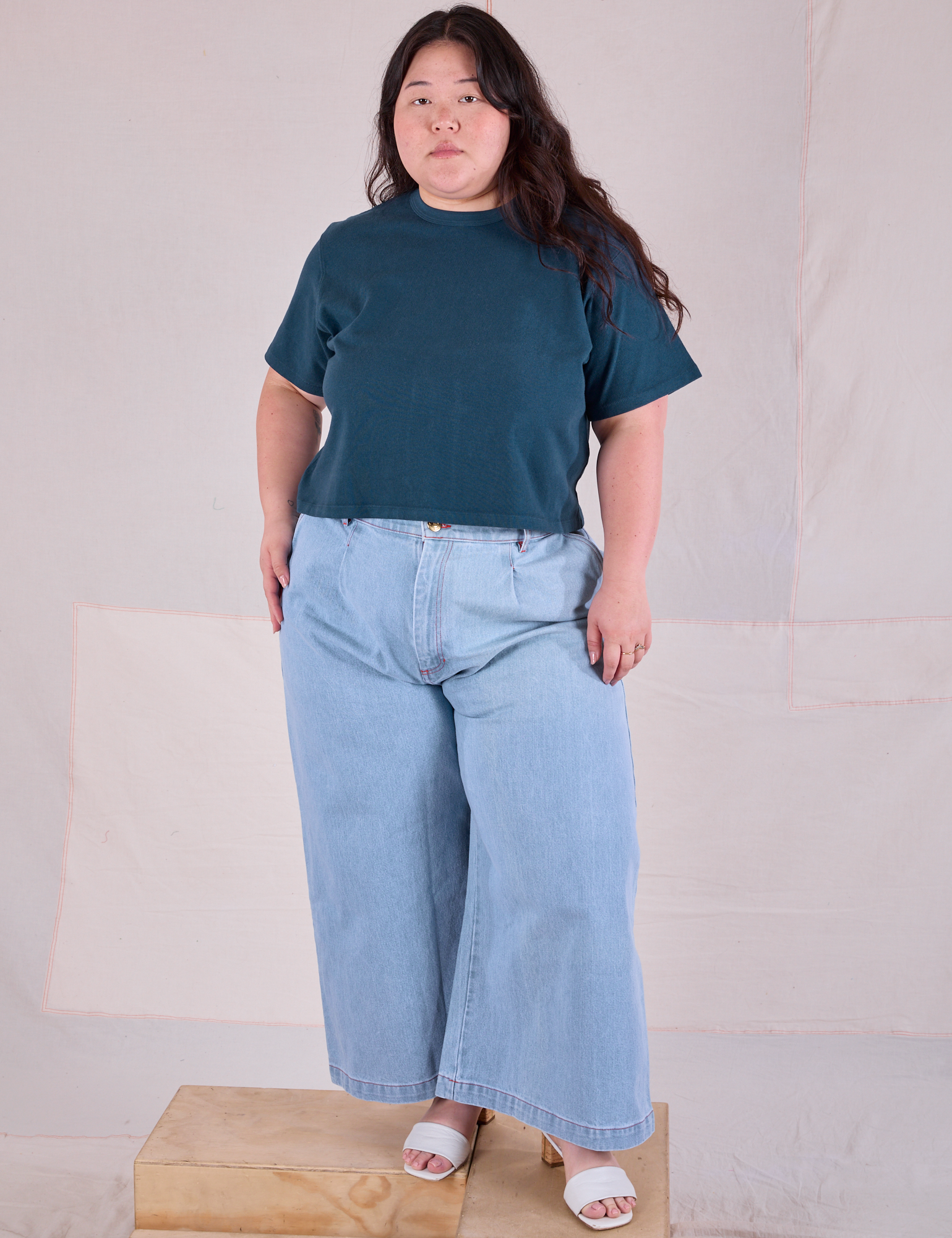 Ashley is wearing Cropped Burly Tee in Lagoon and indigo Wide Leg Denim in Light Wash