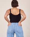 Back view of Cropped Cami in Basic Black and light wash Sailor Jeans worn by Tiara. She has both her hands in the back pant pockets.