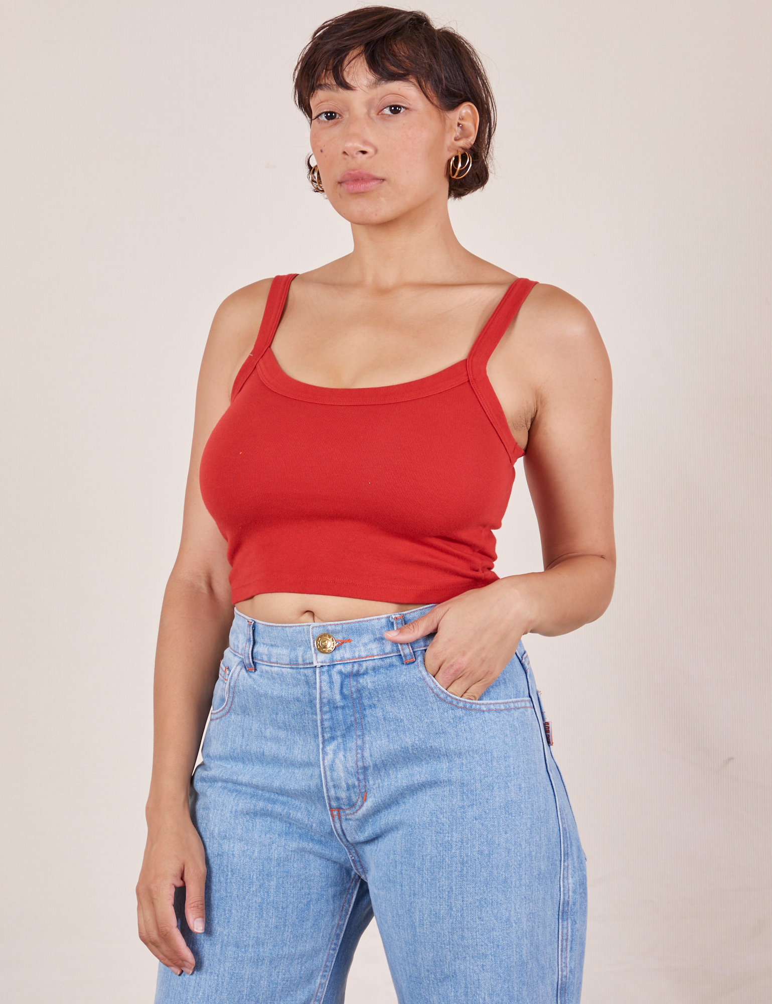 Tiara is wearing Cropped Cami in Mustang Red and light wash Sailor Jeans