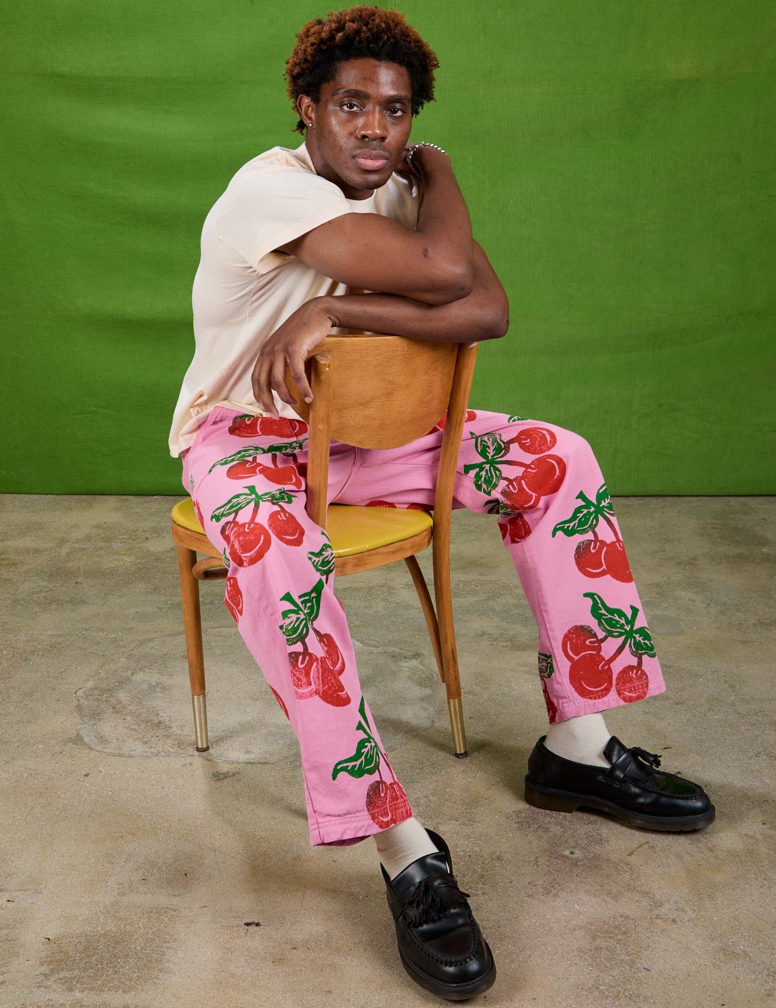 Isaac is wearing Cherry Paintstamped Work Pants in Bubblegum Pink and Organic Vintage Tee in Vintage Off-White
