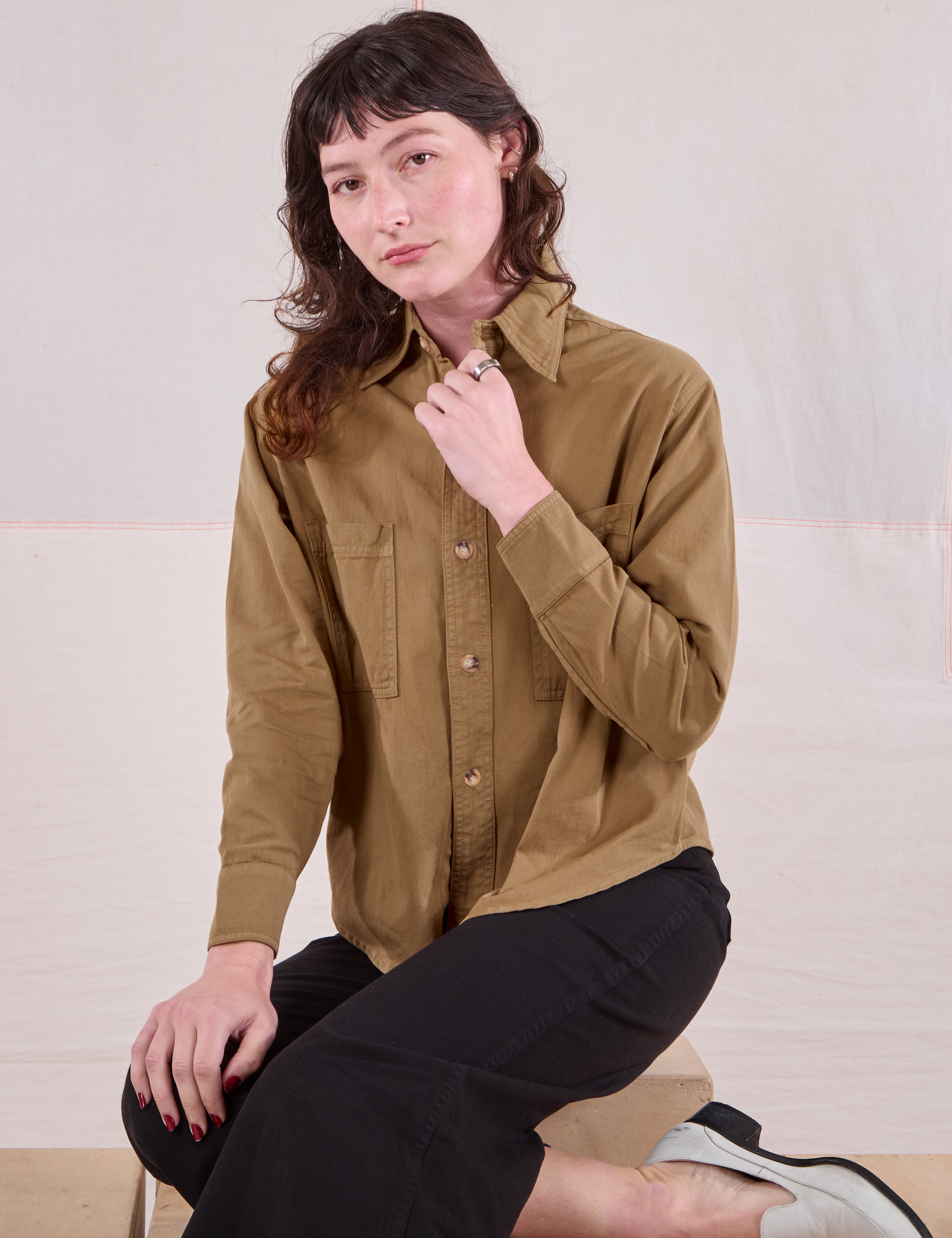 Alex is wearing a buttoned up Cropped Overshirt in Desert Brown