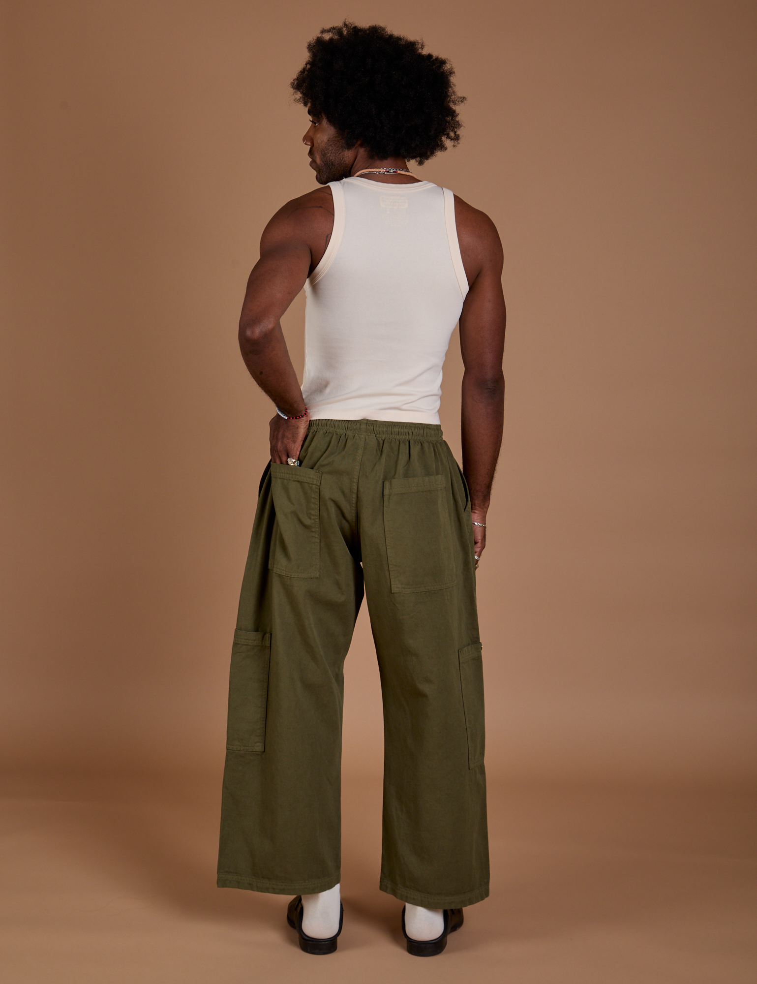 Back view of Drop Pocket Cargo Pants in Surplus Green and Tank Top in vintage tee white on Jerrod