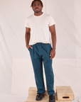 Issac is wearing Easy Pants in Lagoon and Organic Vintage Tee in vintage tee off-white