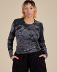 Tiara is 5’4” and wearing S Long Sleeve Baby Tee in Black Magic Waters