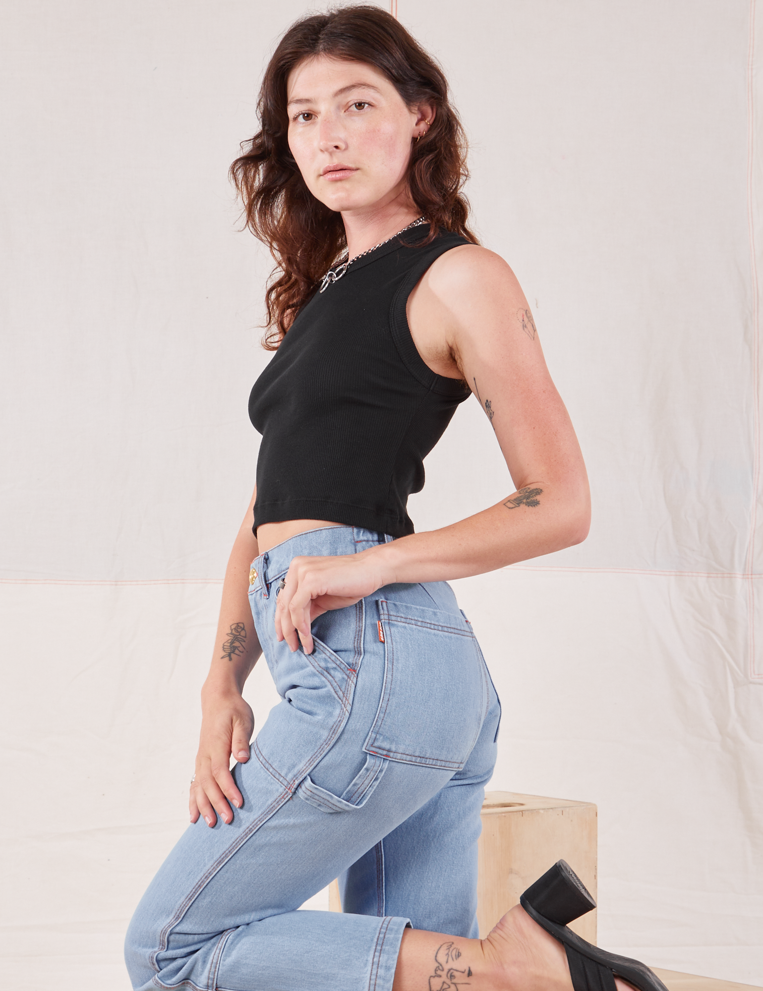 Alex is wearing Muscle Tee in Basic Black and light wash Carpenter Jeans