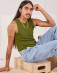 Anthony is wearing Muscle Tee in Summer Olive and light wash Carpenter Jeans