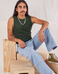 Anthony is wearing Muscle Tee in Swamp Green and light wash Carpenter Jeans