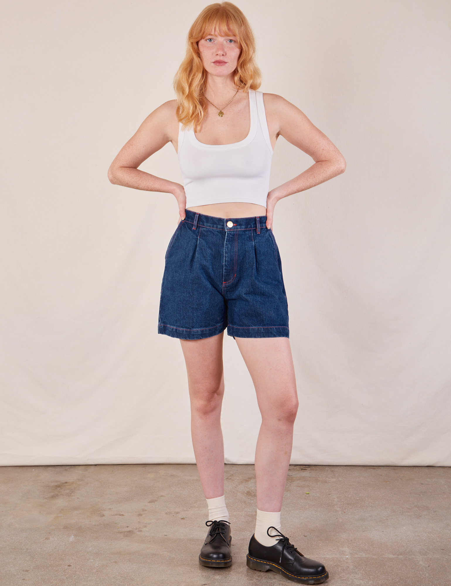 Margaret is 5&#39;11&quot; and wearing XS Denim Trouser Shorts in Dark Wash paired with a Cropped Tank in vintage tee off-white