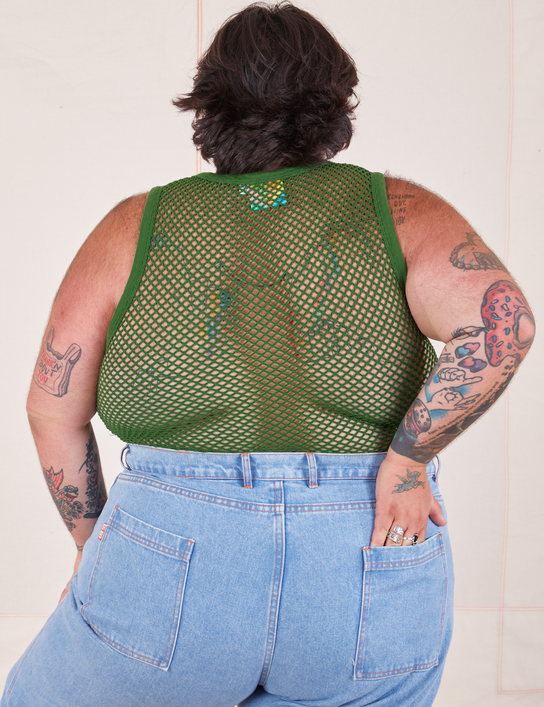 Back view of Mesh Tank Top in Lawn Green and light wash Sailor Jeans worn by Sam