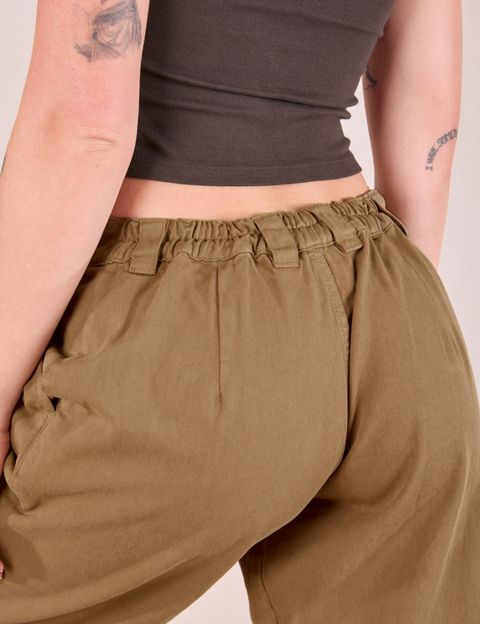 Mid-Rise Pleated Trousers in Desert Brown back close up on Alex