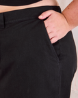 Mid-Rise Pleated Trousers in Basic Black close up of Juliet's hand in pocket.