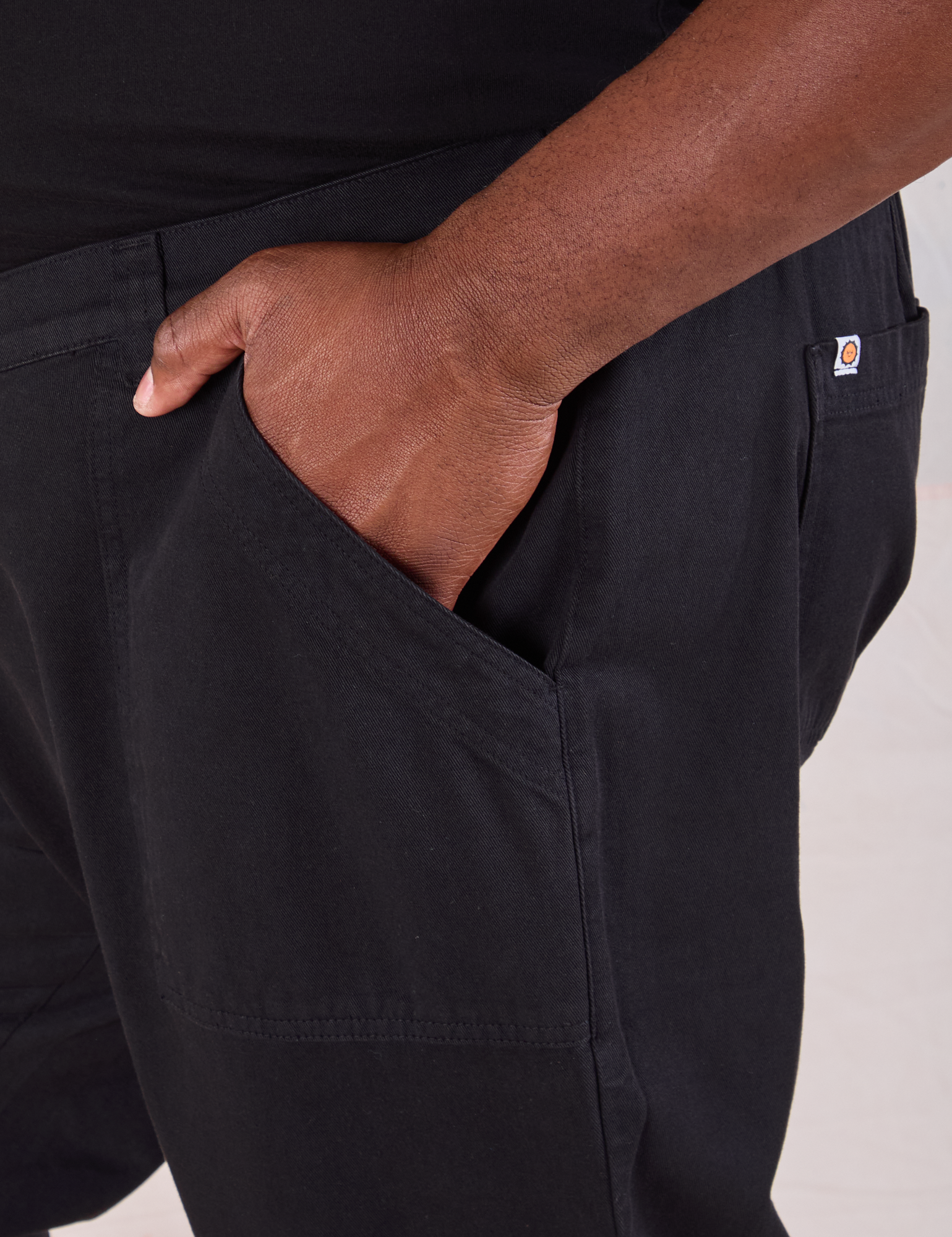 Mid-Rise Work Pants in Basic Black close up of Elijah&#39;s hand in the front pocket