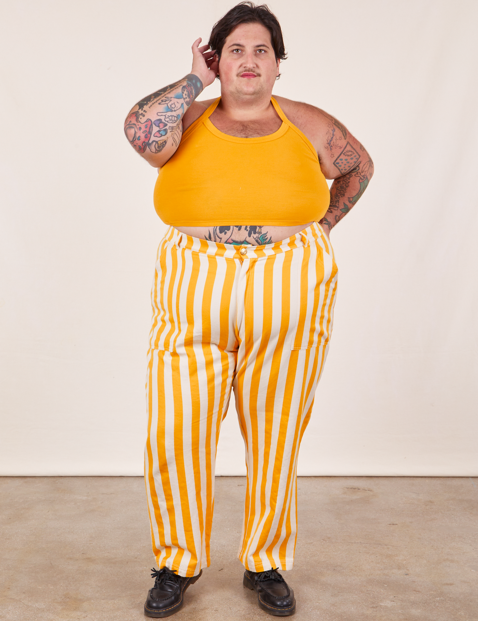 Sam is wearing Work Pants in Lemon Stripe and mustard yellow Halter Top