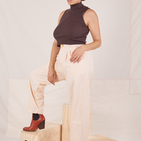 Tiara is wearing Heritage Trousers in Vintage Off-White and the Sleeveless Turtleneck in espresso brown