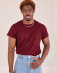 Issac is wearing Organic Vintage Tee in Red Wine tucked into light wash Carpenter Jeans