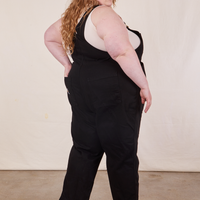 Angled back view of Original Overalls in Mono Black worn by Catie
