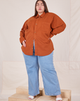 Marielena is wearing a buttoned up Oversize Overshirt in Burnt Terracotta paired with light wash Sailor Jeans