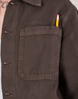 Field Coat in Espresso Brown front pocket close up. Pencil is in the pen pocket slot.