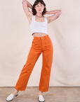 Alex is wearing Work Pants in Construction Orange and a Cropped Tank in Vintage Tee Off-White