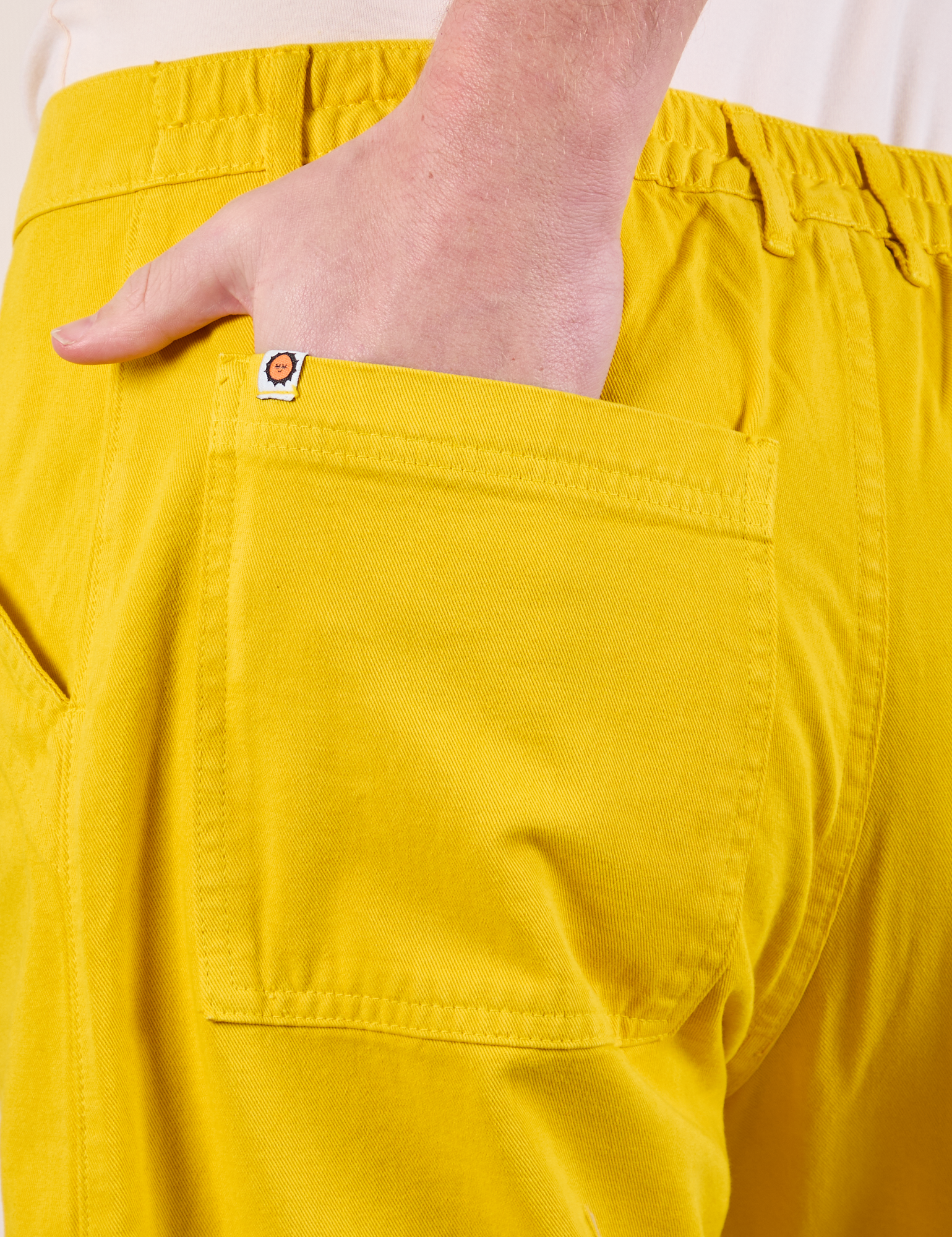 Close up of Quinn&#39;s hand in the back pocket of Work Pants in Golden Yellow