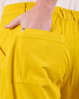 Close up of Quinn's hand in the back pocket of Work Pants in Golden Yellow