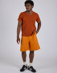 Isaac is 5’10” and wearing M Longline Work Shorts in Creamsicle Orange paired with burnt terracotta Organic Vintage Tee