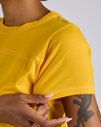 Close up sleeve of Jr. Varsity Tee in Sunshine Yellow on Kira