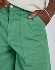 Close up of Isaac's hand in the front pocket of Longline Work Shorts in Seafoam Green