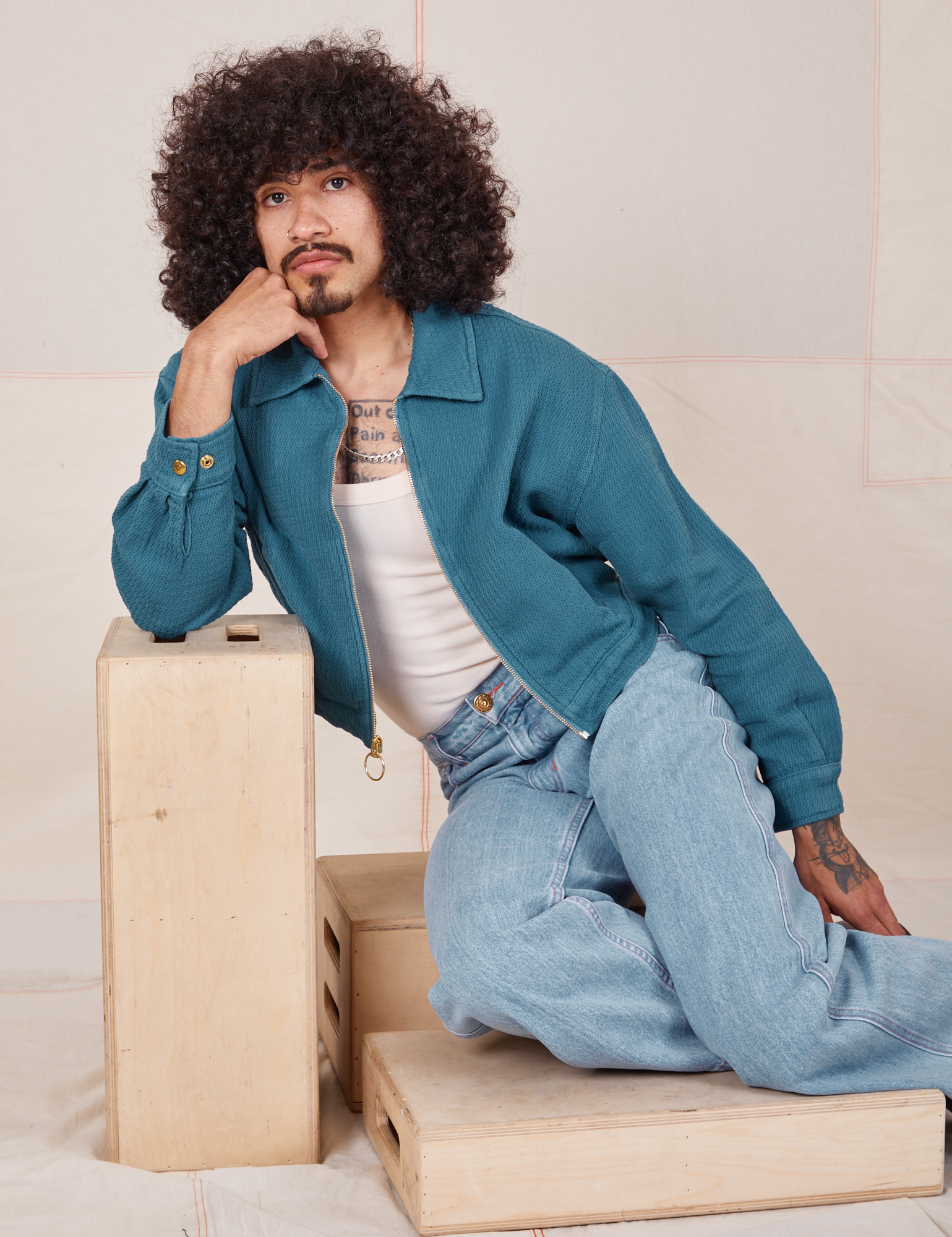 Jesse is 5&#39;8&quot; and wearing XS Ricky Jacket in Marine Blue paired with a vintage off-white Tank Top and light wash Frontier Jeans