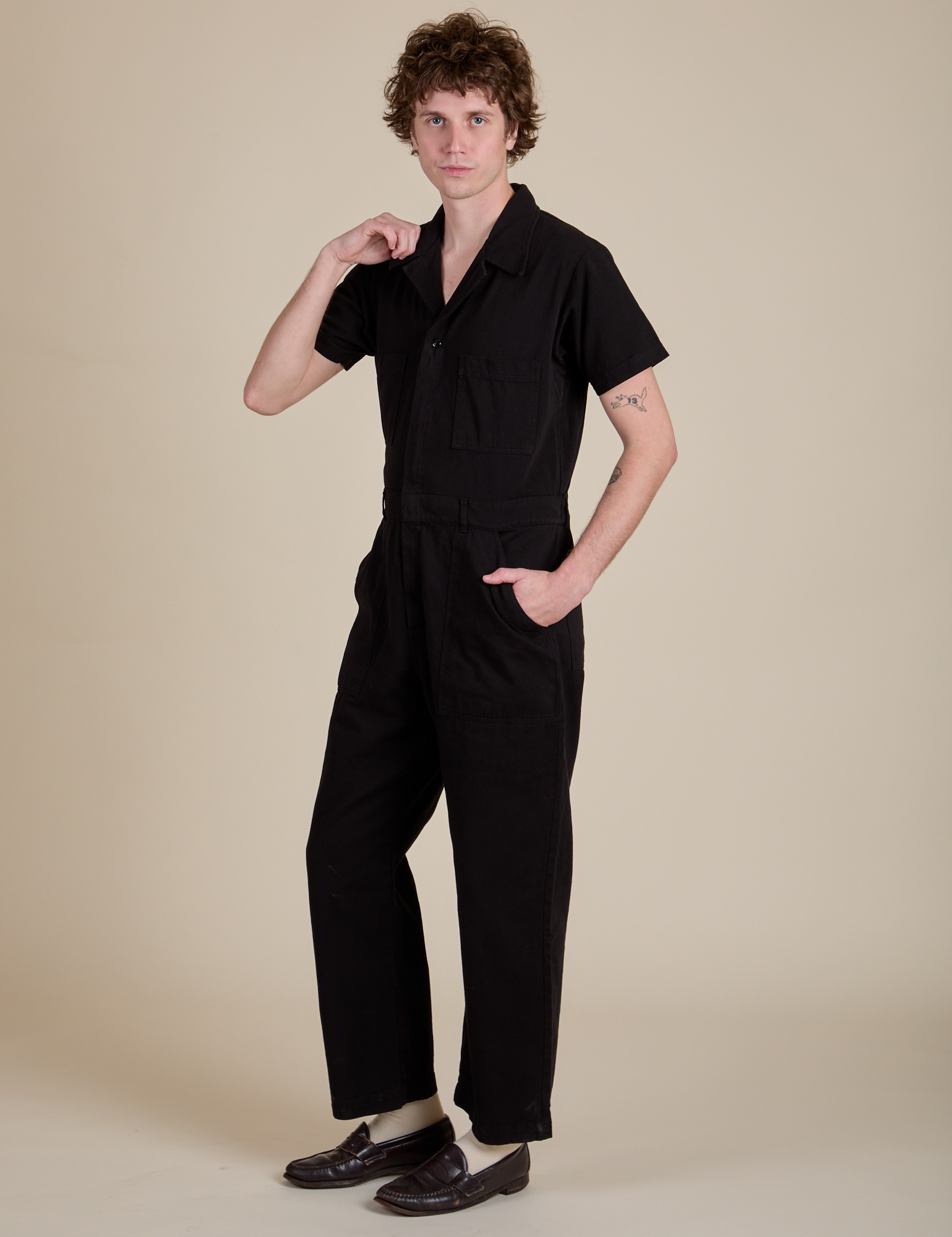Angled front view of Short Sleeve Jumpsuit in Basic Black on Quinn