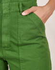 Front pocket close up of Short Sleeve Jumpsuit in Lawn Green. Tiara has her hand in the pocket.