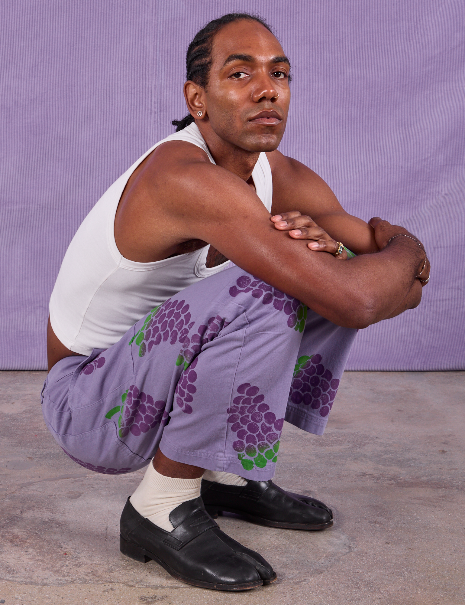 Jerrod is wearing Paintstamped Work Pants in Grape and Cropped Tank in Vintage Tee Off-White