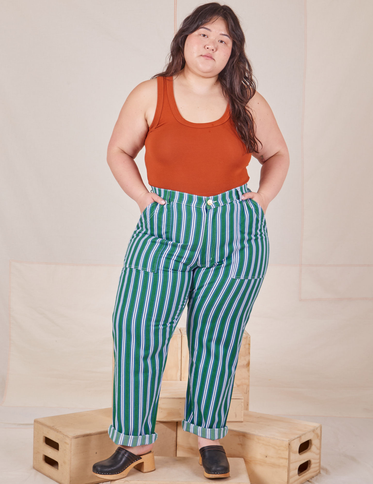 Ashley is 5&#39;7&quot; and wearing 1XL Stripe Work Pants in Green paired with burnt terracotta Cropped Tank