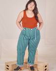 Ashley is 5'7" and wearing 1XL Stripe Work Pants in Green paired with burnt terracotta Cropped Tank