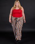 Juliet is 5'7" and wearing 1XL Striped Drop Pocket Pants in Retro Rainbow paired with mustang red Tank Top