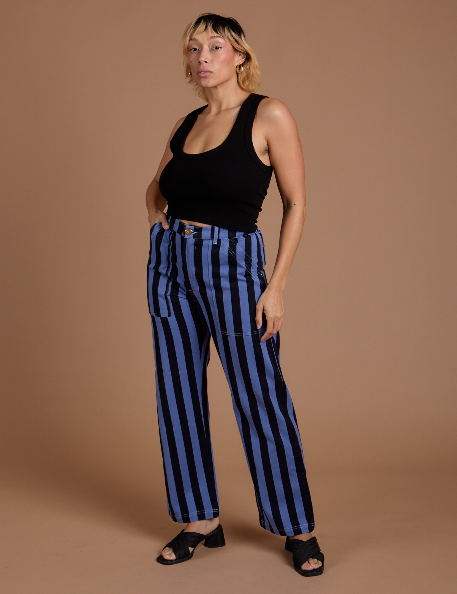 Angled front view of Black Stripe Work Pants in Cornflower Blue and black Cropped Tank on Tiara