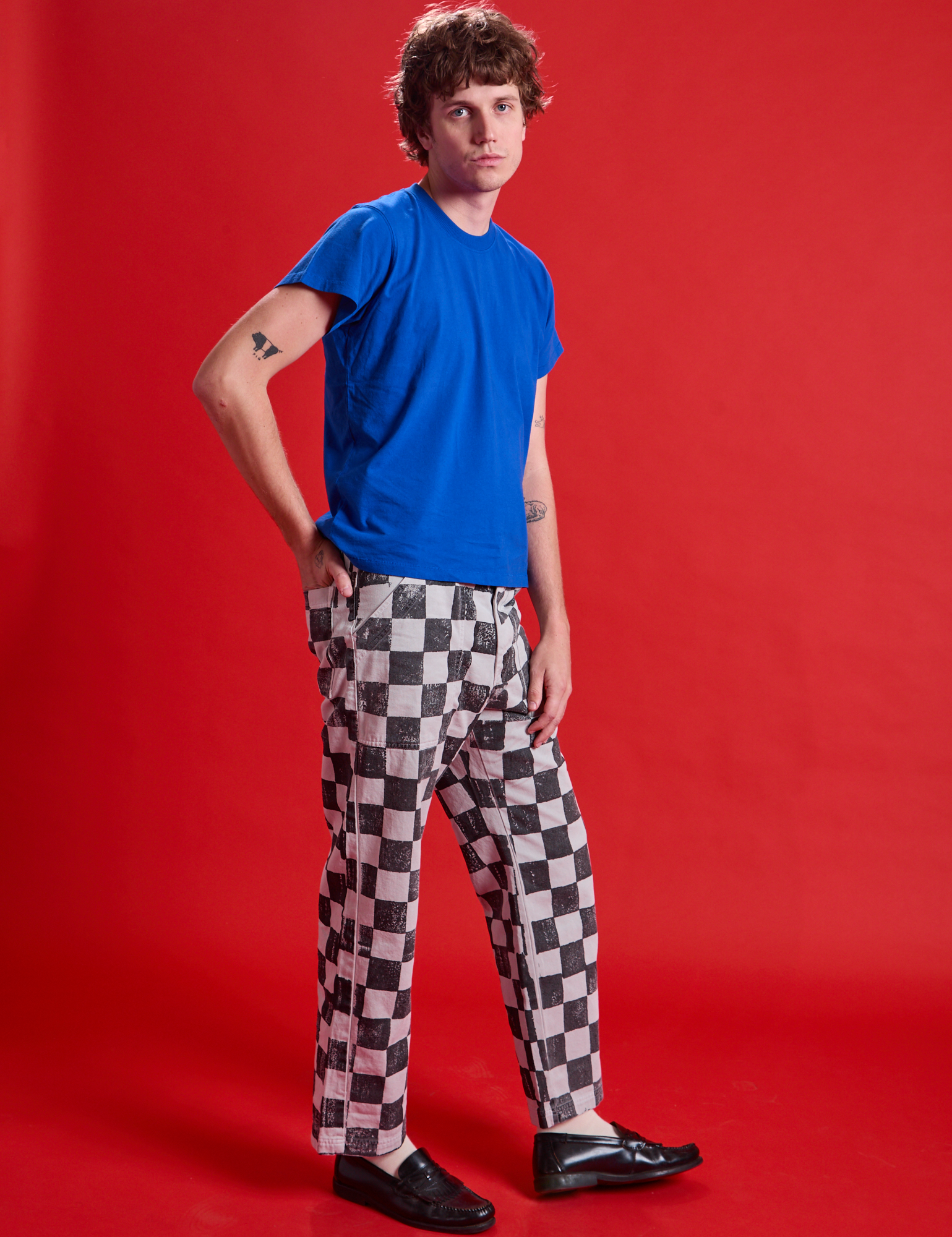 Side view of Checkerboard Work Pants in Black/White and royal blue Organic Vintage Tee on Quinn