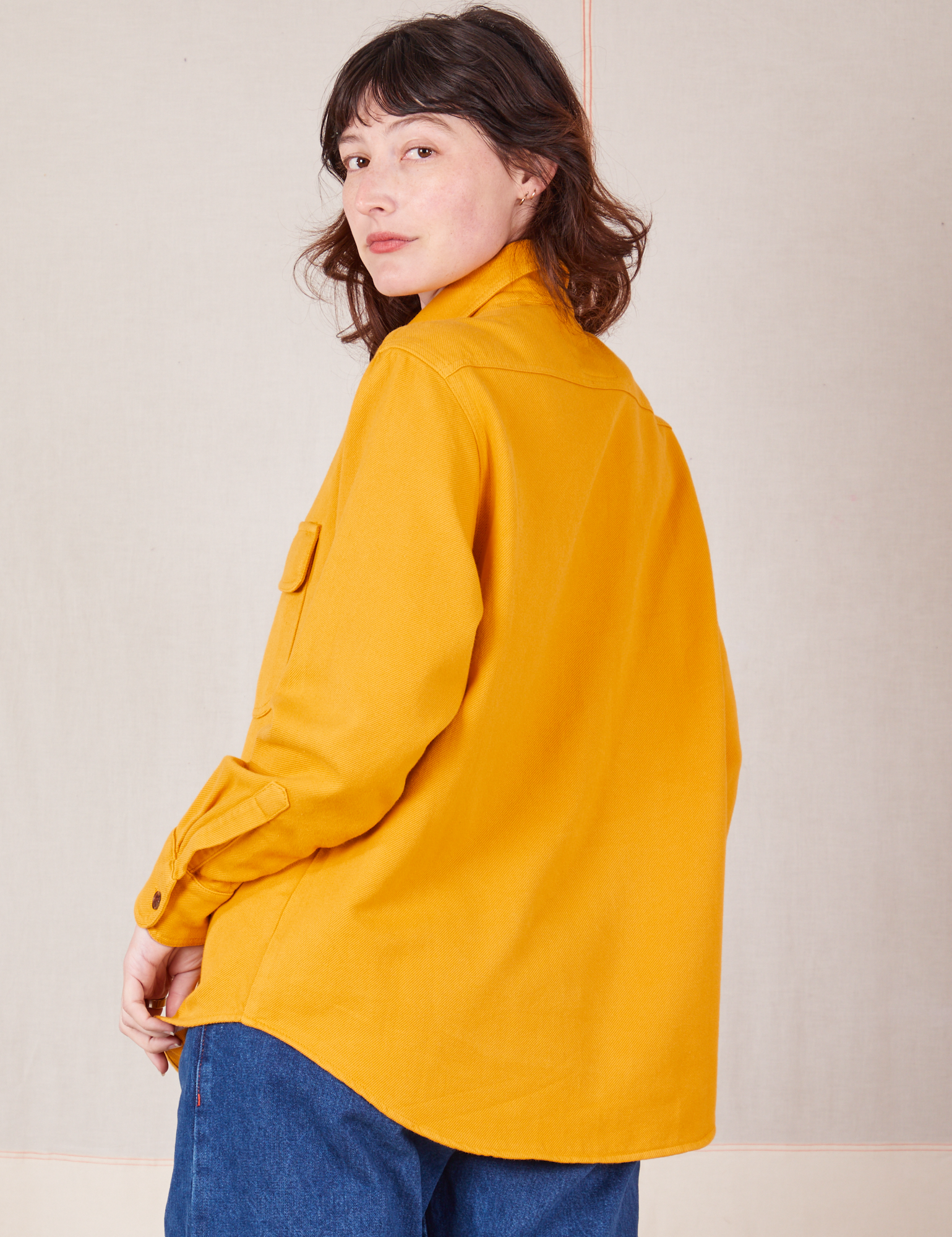 Angled back view of Flannel Overshirt in Mustard Yellow on Alex