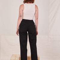 Back view of Denim Trouser Jeans in Black and vintage off-white Tank Top worn by Alex
