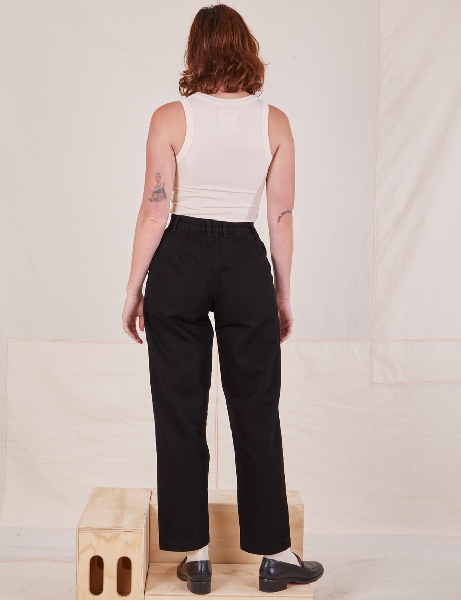 Back view of Denim Trouser Jeans in Black and vintage off-white Tank Top worn by Alex