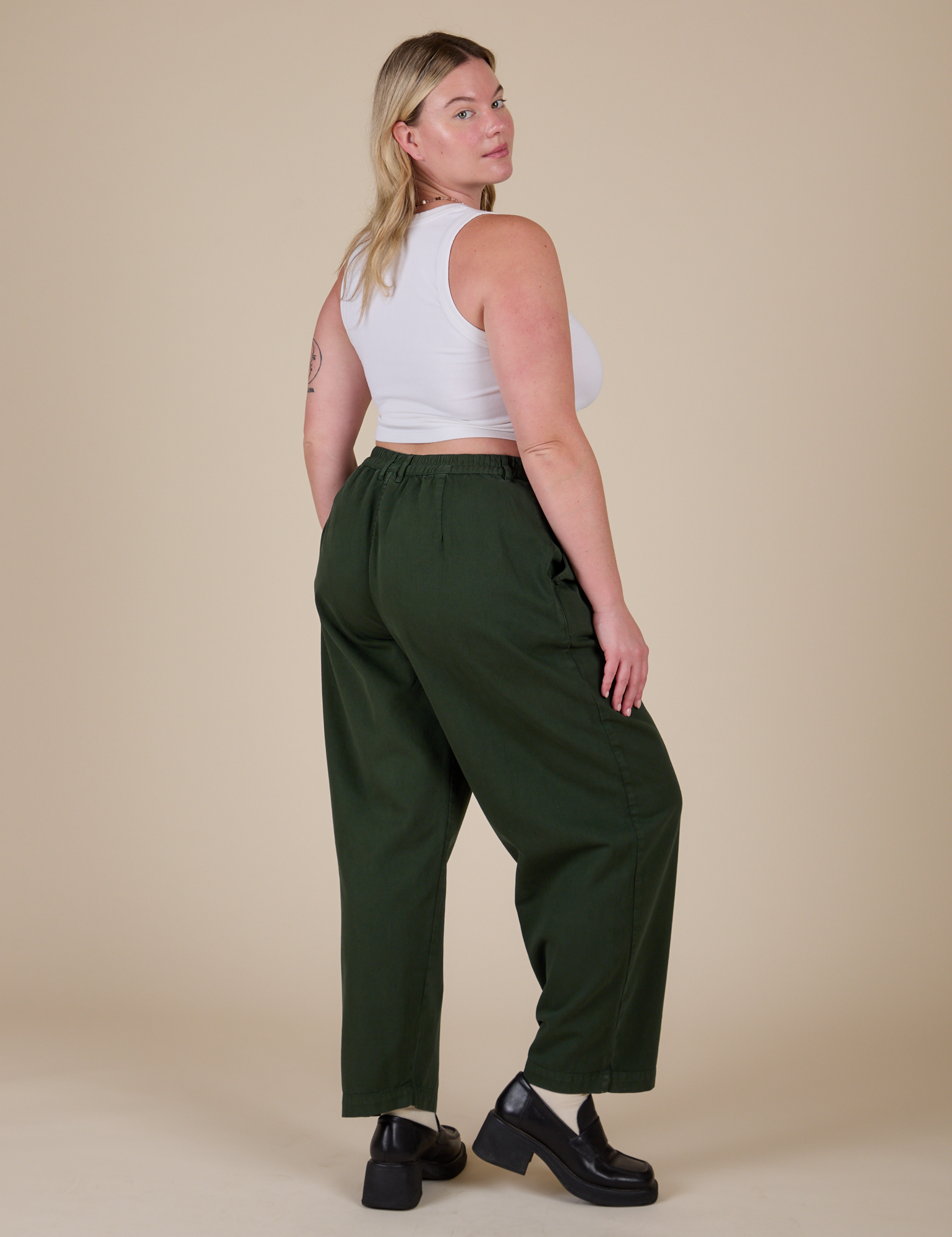 Angled back view of Heavyweight Trousers in Swamp Green and Cropped Tank in Vintage Tee White on Lish