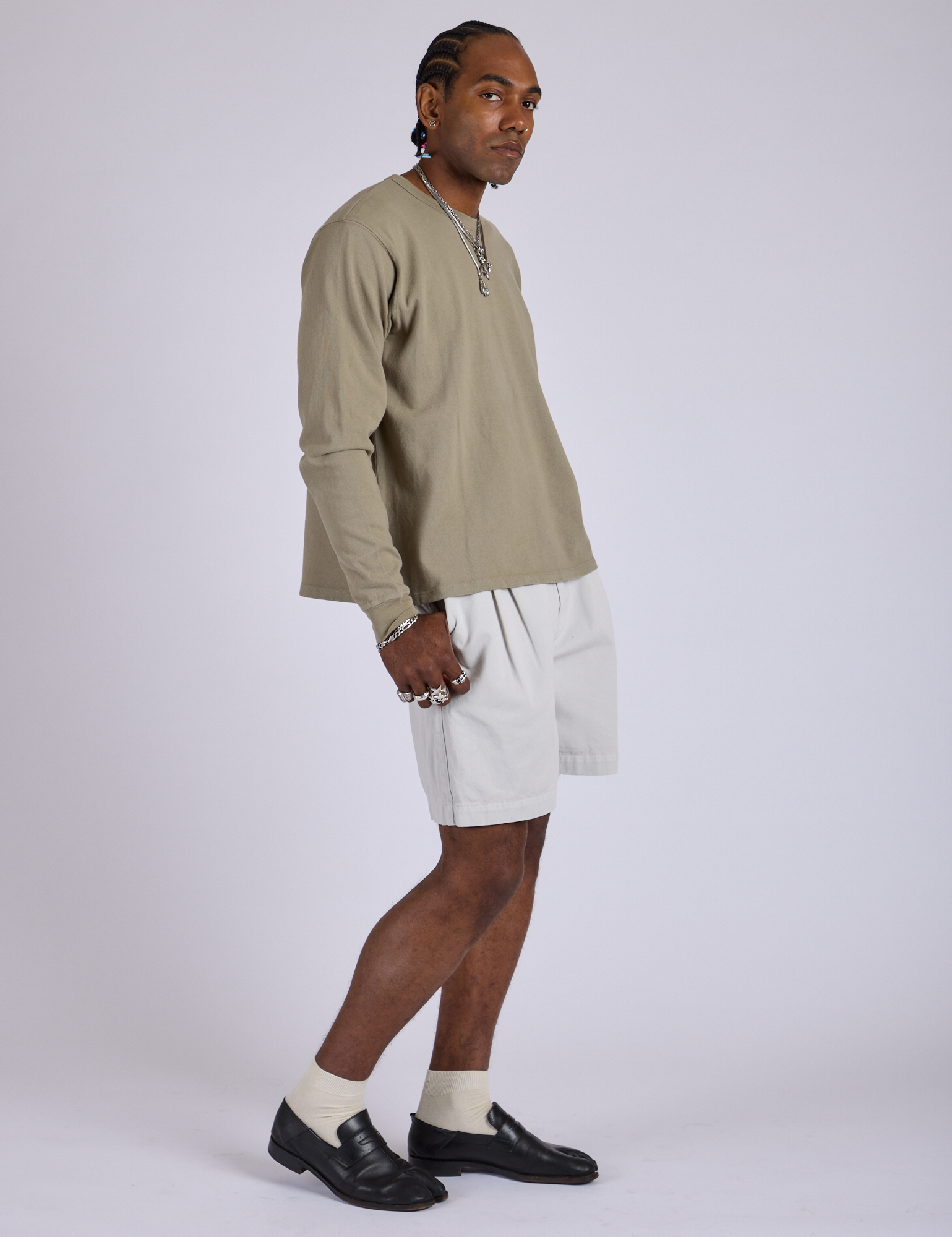 Side view of Pleated Trouser Shorts in Dishwater White and khaki grey Long Sleeve Bury Tee on Jerrod