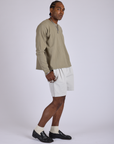 Side view of Pleated Trouser Shorts in Dishwater White and khaki grey Long Sleeve Bury Tee on Jerrod