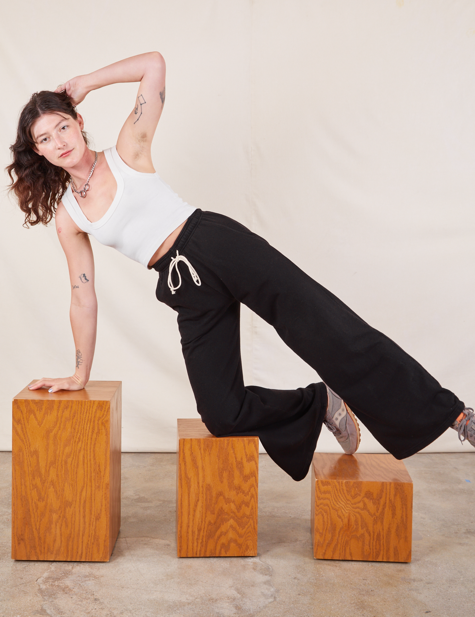 Alex is wearing Wide Leg Sweat Pants in Basic Black and Cropped Tank in vintage tee off-white