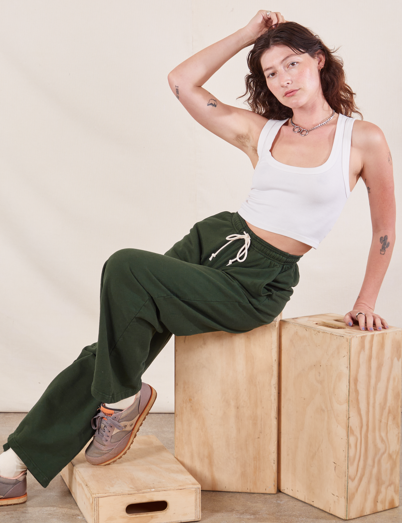 Alex is wearing Wide Leg Sweat Pants in Swamp Green and Cropped Tank in vintage tee off-white