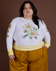 Sam is 5’10” and wearing XL Floral Long Sleeve Baby Tee in Yellow