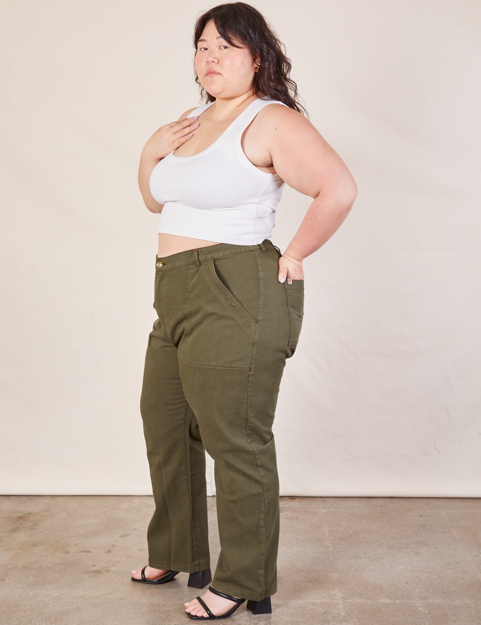 Side view of Work Pants in Surplus Green and Cropped Tank in vintage tee off-white on Ashley