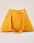 Overall Handbag in Mustard Yellow with handle strap down across front
